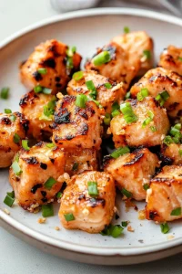 Small salmon portions with a glossy finish and fresh garnish for contrast.