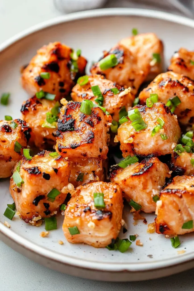 Small salmon portions with a glossy finish and fresh garnish for contrast.