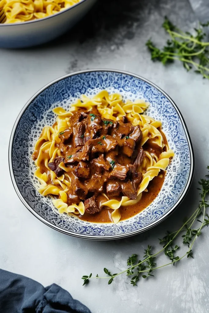 Tender beef chunks in glossy brown gravy served over egg noodles.