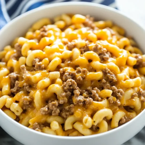 Comfort food serving of cheesy noodles with browned beef pieces.