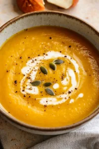 Soup with glossy finish, seeds scattered across the creamy topping.