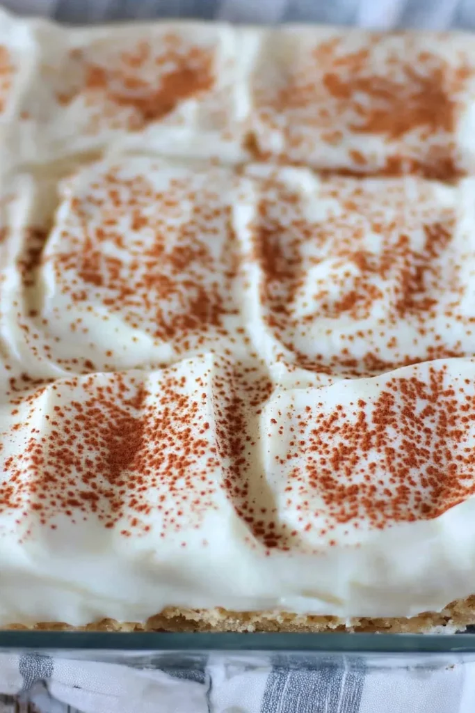 Soft sponge dessert layered with rich cream and cocoa powder sprinkle.