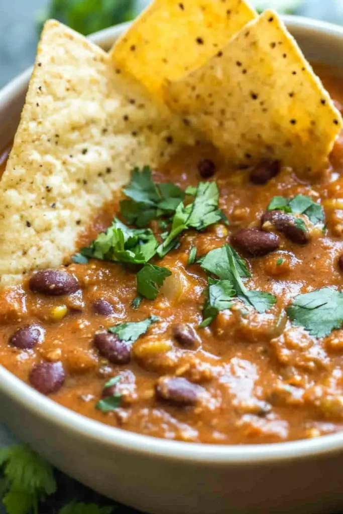 Savory bean dip with crunchy chips arranged in the bowl
