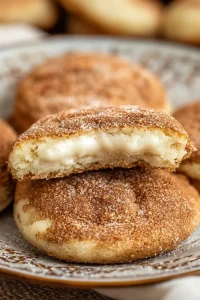 Golden hand pies dusted with cinnamon sugar, arranged neatly on a patterned plate.