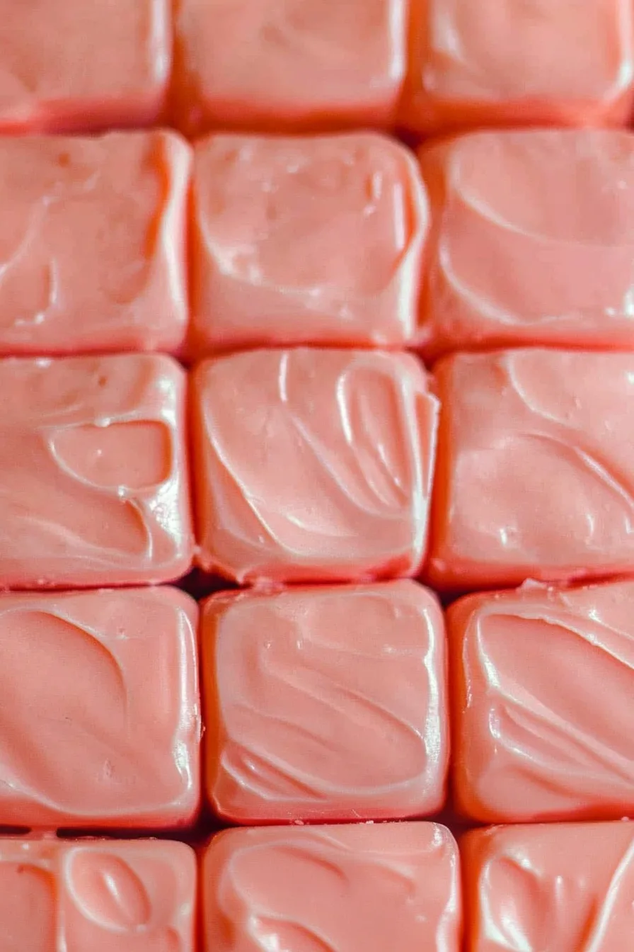 Close-up of creamy pink dessert bars with smooth tops.