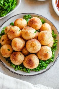 Plate of round, golden appetizers arranged in a pyramid style.
