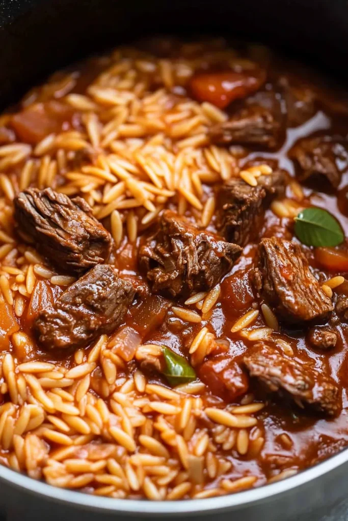 Overhead view highlighting the tomato-based sauce clinging to pasta and meat.