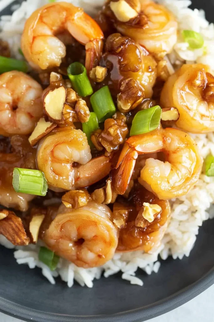 Shrimp glistening under a savory glaze, paired with nuts for texture and contrast.