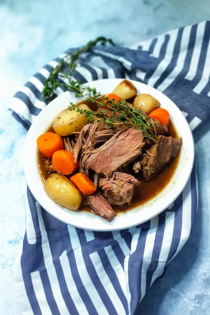 Plated comfort meal with golden potatoes, carrots, and fresh herbs.
