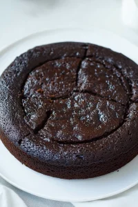 Moist black cake showing its dense texture and glossy surface.