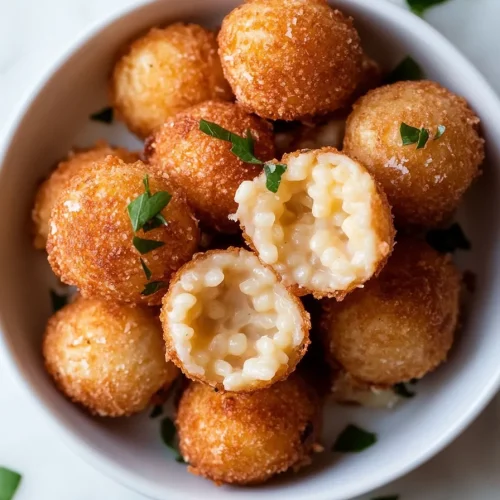Crispy arancini cut open to reveal cheesy mushroom risotto inside.