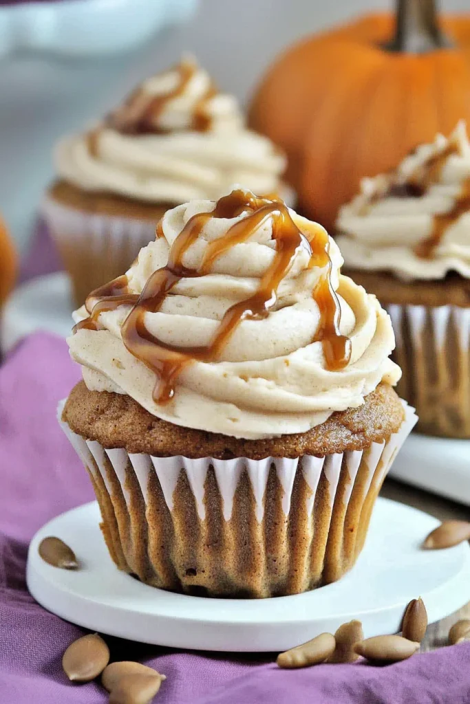 Plated cupcake surrounded by pumpkins, highlighting fall flavors.