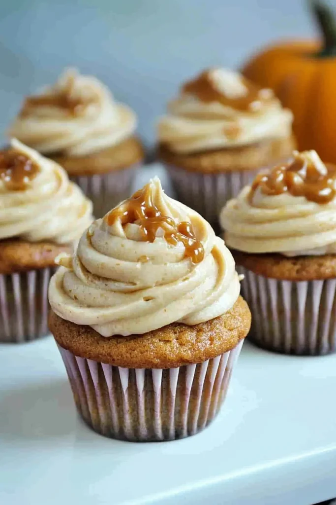 Cupcake in paper liner with caramel topping and smooth swirl.