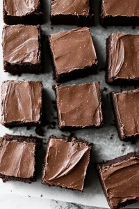 Squares of moist chocolate brownies topped with smooth frosting.