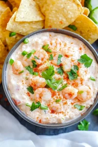 Appetizer scene featuring a thick, white dip with shrimp and spices, ready for dipping.
