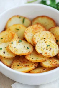 Rustic potato rounds with herbs, served in a simple white dish