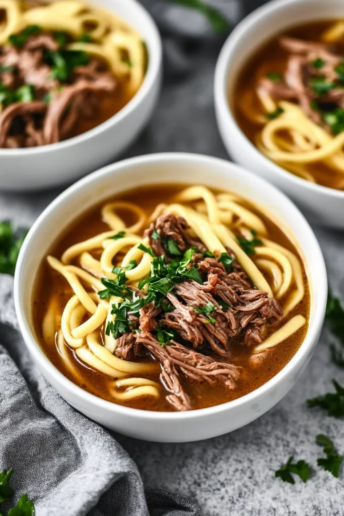 Warm noodle dish highlighting tender beef pieces and glossy broth.