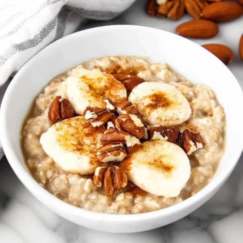 Overhead view of hearty oatmeal garnished with almonds and spice.
