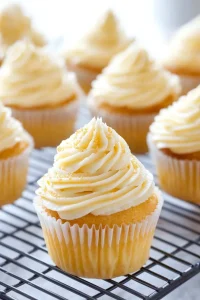 Closeโup of frosted cupcakes arranged neatly on a tray, showcasing their soft texture and creamy swirl topping.