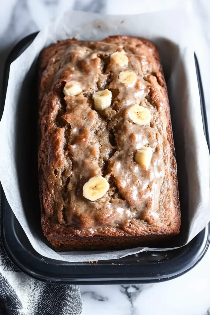Loaf topped with light icing, highlighting the contrast between crust and soft center.