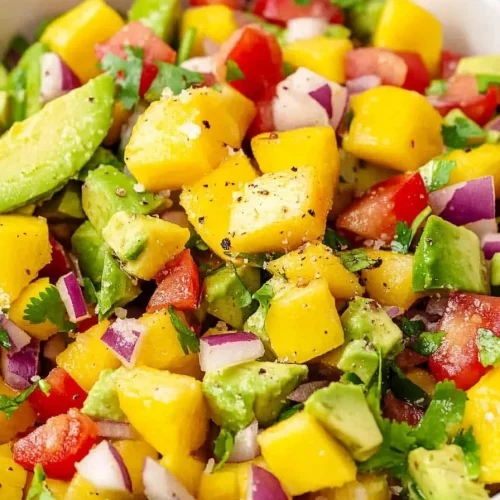 Colorful mix of diced mango, avocado, and tomato.