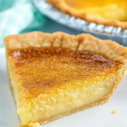 Close-up of flaky crust and silky yellow custard topped with a browned surface.