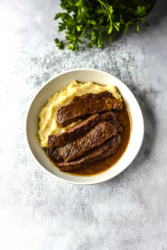 Tender slices of beef served with rich brown gravy and mashed potatoes.